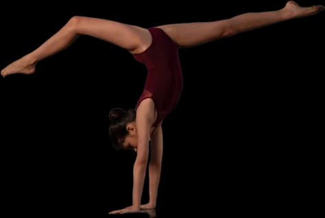 Dancer holding a walkover in a burgundy leotard